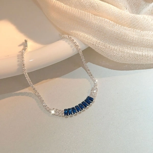 Close-up of silver link bracelet featuring rectangular blue gemstones and white zirconia