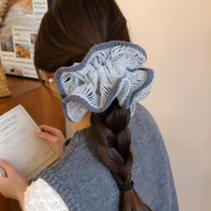 Macro detail of oversized knit flower scrunchie in grey-blue with dark trim