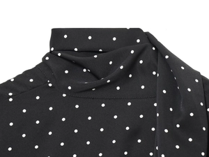 Dettaglio del collo con fiocco e della fantasia a pois bianchi su chiffon nero