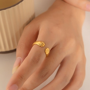 Detailed close-up of 18K gold plated hugging hands ring with adjustable open band design