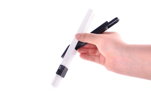 Detail of hand holding a black plastic gap cleaning brush with white bristles for small parts