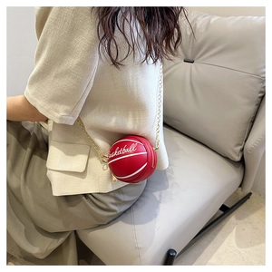 Close-up of a red basketball-shaped mini crossbody bag with a gold chain strap