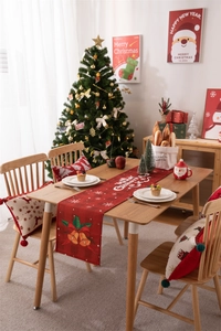 Detail of red Christmas table runner and pillowcase with Merry Christmas text and bells