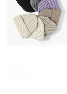 Detailed flat lay of knitted beanies in various colors with vertical ribbed texture