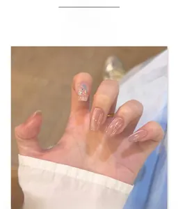 Close-up of nude cat-eye press-on nails with glitter sequins and bow accents, model JL0705