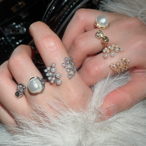 Macro detail of French vintage multi-layer pearl rings with zircon on faux fur background