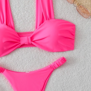 Ensemble bikini rose avec haut à nœud et culotte froncée sur fond en peluche blanche