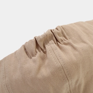 Detail of herringbone fabric and reinforced stitching on a beige duckbill cap
