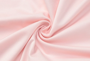 Close-up detail of soft pink ribbed fabric with elegant twisted pleats and texture