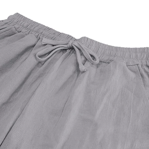 Detail view of elastic waist with drawstring on light gray linen trousers for men