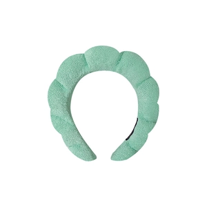 Close-up of light green sponge headband with soft wavy texture and high top design