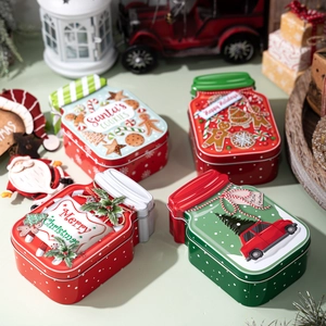 Set of four Christmas tin boxes with Santa and gingerbread man designs for candy storage