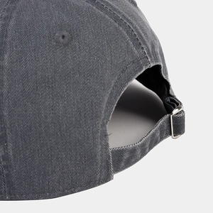 Adjustable silver metal buckle on the back of a vintage washed cotton short brim baseball cap