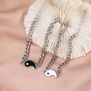 Detailed view of silver tone Yin Yang couple bracelets with black and white charms