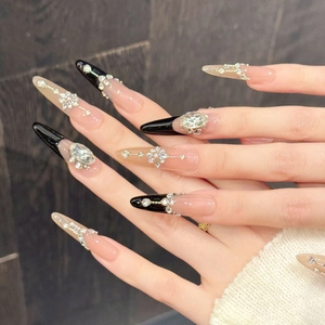 Close-up of luxury long stiletto press-on nails with black pink rhinestones