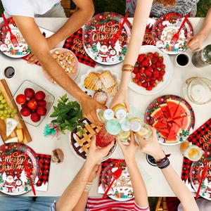 Flat lay of Christmas party paper plates and napkins with Santa and snowman patterns