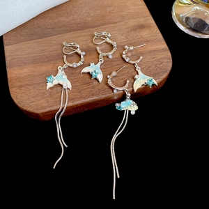 Detailed shot of fish tail earrings with pearls, blue rhinestones and silver tassels