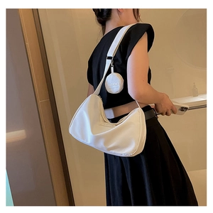 Detail of minimalist beige dumpling tote bag with detachable round coin purse on strap