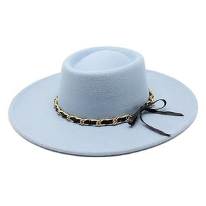 Detail of light blue felt fedora hat featuring gold chain trim and black bow accent