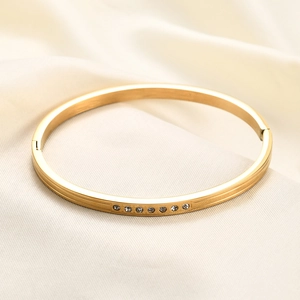 Close-up of 18K gold-plated stainless steel bangle with seven inlaid cubic zirconia stones