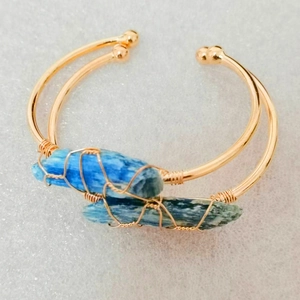 Bracciali aperti placcati in oro con cristalli di cianite grezza e dettagli in filo metallico