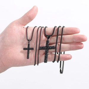 Macro view of black stainless steel cross necklaces in two sizes for scale comparison