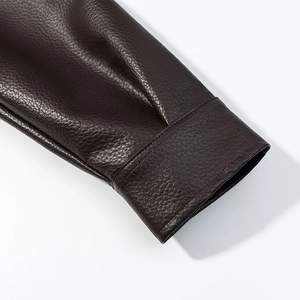 Close-up of deep brown PU leather jacket cuff with high-quality litchi grain texture