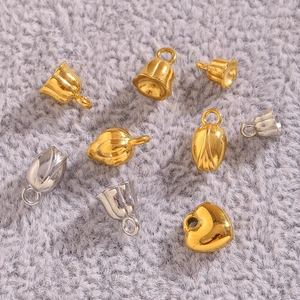 Détails macro de pendentifs cœur et lys en or et argent sur un fond en peluche grise