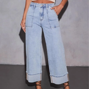 Detail van lichtblauwe wide-leg jeans met hoge taille en symmetrische opgestikte zakken