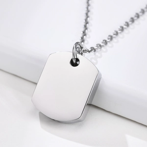 Macro shot of silver stainless steel rectangular dog tag pendant and metal chain link