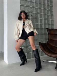Chic cream white zip-up bomber jacket styled with black high leather boots for women