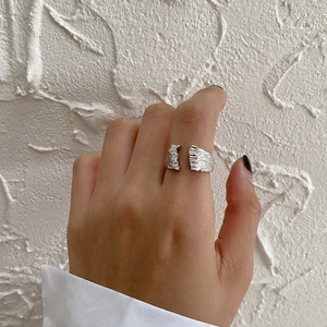 Close-up of S925 sterling silver open ring featuring irregular lava texture on finger