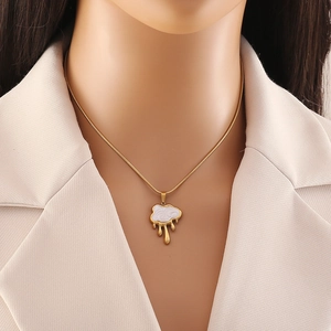 Collana a nuvola dorata con ciondolo a nappa in smalto bianco su modella di moda