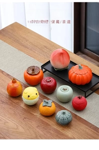 Collezione di barattoli da tè creativi in ceramica a forma di frutta su tavolo di legno