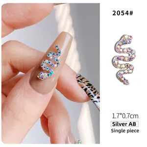 Macro detail of snake-shaped nail charm with silver AB rhinestones for 3D manicures