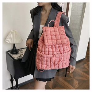 Dettaglio dello zaino trapuntato rosa con texture in cotone piumino leggero e spalline morbide