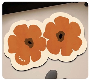 Close-up of dual orange floral bath mats with soft textures and Fancy typography detail