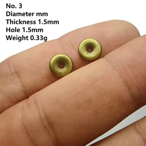 Macro shot of 1.5mm thickness bronze wheel spacers held on fingertips for jewelry making