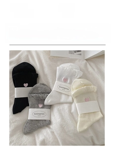 Detail of four-pack cotton socks featuring pink heart embroidery and soft lace edges
