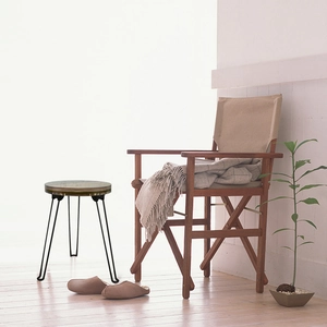 Macro detail of a minimalist round side table with green marble texture and black metal legs