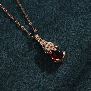 Rose gold necklace with mythical Pixiu pendant and a large oval deep red gemstone