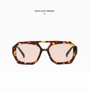 Detailed close-up of tortoise shell sunglasses with double bridge and pink-brown lenses