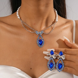 Detail of luxury necklace with blue drop crystal and white pearl beaded chain