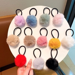 Detail view of 12-piece colorful faux rabbit fur pom pom hair ties set on display