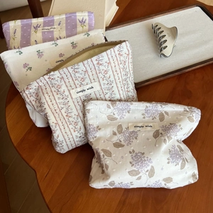 Detailansicht von vier gesteppten Baumwoll-Kosmetiktaschen mit Blumenmuster und Zipper
