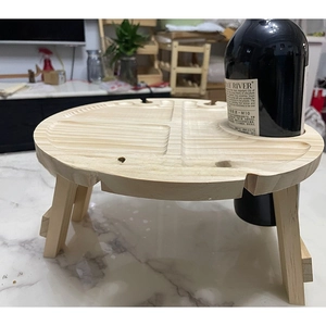Close-up of a folding wooden picnic table with dedicated wine bottle and glass slots