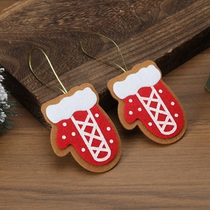 Detail of red and white felt Christmas glove ornaments with gold string on a wooden tray