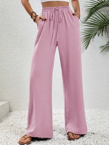 Detail of high waisted wide leg trousers with elastic drawstring and side pockets