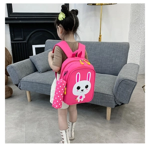 Pink toddler backpack with cartoon rabbit pattern and matching pencil case on a child