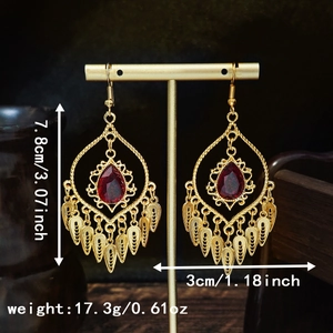 Detailed view of bohemian gold earrings with red gems and leaf tassels including dimensions